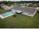 Aerial view of a private backyard featuring a sparkling in-ground pool, screened-in patio, and lush green grass at 123 Jeffrey Dr, Brandon, FL 33511