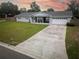 Charming single story home featuring manicured lawn, stone details, attached garage, and a long concrete driveway at 123 Jeffrey Dr, Brandon, FL 33511