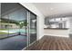 Open living space with sliding glass doors to the screened patio with pool view, leading into updated kitchen at 123 Jeffrey Dr, Brandon, FL 33511