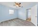 Light blue bedroom featuring ceiling fan and wood-look flooring, with doorway to another room at 12400 Park Blvd # 311, Seminole, FL 33772