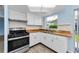 Well-lit kitchen with white cabinets, wooden countertops, and modern appliances at 12400 Park Blvd # 311, Seminole, FL 33772