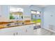 Bright kitchen featuring a wood countertop, stainless steel sink, and sliding glass doors to the backyard at 12400 Park Blvd # 311, Seminole, FL 33772