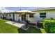 A cozy patio with a well-maintained lawn, an air conditioner, and a patio umbrella at 12400 Park Blvd # 311, Seminole, FL 33772