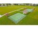 Aerial view of fenced basketball courts with a covered pavilion area, surrounded by manicured lawns at 13334 Palmera Vista Dr, Riverview, FL 33579