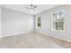 Neutral bedroom with tile flooring, ceiling fan, and two bright, screened windows at 13334 Palmera Vista Dr, Riverview, FL 33579