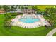 Aerial view of community pool with lounge chairs, tables, and many palm trees at 13334 Palmera Vista Dr, Riverview, FL 33579