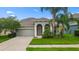Charming single-story home with a manicured lawn, mature trees, and neutral paint at 13334 Palmera Vista Dr, Riverview, FL 33579