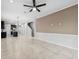 View of the open floor plan shows the tile floors, ceiling fan, and kitchen in this modern home at 13334 Palmera Vista Dr, Riverview, FL 33579