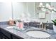 Double sink bathroom vanity with granite countertops, dark cabinets, decorative coral, and jars with shells and cotton balls at 13520 White Sapphire Rd, Riverview, FL 33579