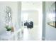 Hallway leading into a living room, featuring tile flooring and decorative wall art and table at 13520 White Sapphire Rd, Riverview, FL 33579