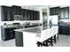 Modern kitchen featuring dark cabinets, stainless steel appliances, and a spacious island with bar seating at 13520 White Sapphire Rd, Riverview, FL 33579