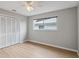 This bedroom features hardwood floors, a window, a ceiling fan, and a closet at 13986 Bonnie Brae Dr, Largo, FL 33774