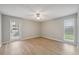 This bedroom features hardwood floors, ceiling fan, a window, and a glass door at 13986 Bonnie Brae Dr, Largo, FL 33774