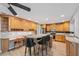 Bright kitchen with light wood cabinetry, center island with bar seating, and stainless steel appliances at 13986 Bonnie Brae Dr, Largo, FL 33774