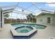 Screened-in pool area with a jacuzzi and patio seating in a well-maintained outdoor space at 13986 Bonnie Brae Dr, Largo, FL 33774