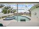 Enclosed pool and spa area featuring a screen enclosure, patio seating, and a bright, airy atmosphere at 13986 Bonnie Brae Dr, Largo, FL 33774