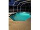 Enclosed, illuminated pool and spa area with a clear view of the water and surrounding decking at night at 13986 Bonnie Brae Dr, Largo, FL 33774