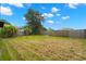 Large backyard with a mix of grass, mature trees, and a wooden fence at 1421 Vinetree Dr, Brandon, FL 33510