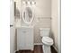 Well-lit bathroom featuring a white vanity, oval mirror, and wood-look flooring at 1421 Vinetree Dr, Brandon, FL 33510