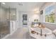 Bright bathroom with a large tub, walk-in shower and view from the window, leading to a large walk-in closet at 14626 Horse Trot Rd, Lithia, FL 33547