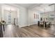 Open-concept dining area with wood floors, modern light fixture, and decorative wall art at 14626 Horse Trot Rd, Lithia, FL 33547