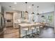 Bright kitchen showcasing stainless steel appliances, large island with seating, and modern pendant lighting at 14626 Horse Trot Rd, Lithia, FL 33547