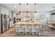 Bright kitchen featuring stainless steel appliances, a large island with seating, and modern pendant lighting at 14626 Horse Trot Rd, Lithia, FL 33547