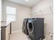 Well-equipped laundry room with modern washer and dryer, shelving, and counter space at 14626 Horse Trot Rd, Lithia, FL 33547