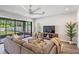 Cozy living room with plush sectional seating, view to the outdoor patio, and modern ceiling fan at 14626 Horse Trot Rd, Lithia, FL 33547