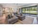 Open concept living room with a large sectional, view to kitchen, and sliding glass doors to the backyard at 14626 Horse Trot Rd, Lithia, FL 33547