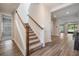 Inviting foyer with wood-look flooring, carpeted stairs, and neutral paint colors at 14626 Horse Trot Rd, Lithia, FL 33547