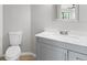 Clean bathroom featuring a modern vanity with marble countertop, toilet, and decorative mirror at 15846 Glenarn Dr, Tampa, FL 33618