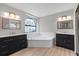 Modern bathroom featuring dual vanities, a soaking tub, and neutral decor at 15846 Glenarn Dr, Tampa, FL 33618