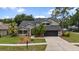 Two-story house with a well-manicured lawn, black shingle roof, two car garage, and mature landscaping at 15846 Glenarn Dr, Tampa, FL 33618