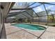 Backyard oasis featuring a screened-in pool and spa, with a brick deck, and partial shade at 15846 Glenarn Dr, Tampa, FL 33618