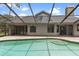 Backyard pool with a screen enclosure, surrounding brick patio, and partial shade at 15846 Glenarn Dr, Tampa, FL 33618
