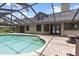Beautiful backyard oasis with a screened-in pool, brick patio, and attached outdoor dining and cooking areas at 15846 Glenarn Dr, Tampa, FL 33618