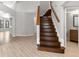 Bright, naturally lit foyer with light hardwood floors and an elegant wooden staircase at 15846 Glenarn Dr, Tampa, FL 33618