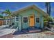 Charming home featuring a yellow door, complemented by flower-filled window boxes and mature landscaping at 1801 52Nd S St, Gulfport, FL 33707