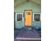Inviting front entrance with a bright yellow door, flower boxes, and clear home security signage at 1801 52Nd S St, Gulfport, FL 33707