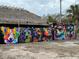 A wall mural of colorful dogs next to a palm tree and thatched roof structure at 1801 52Nd S St, Gulfport, FL 33707
