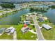 Aerial view showcases home with solar panel, manicured lawn, and serene water access at 1811 Milford Cir, Sun City Center, FL 33573