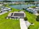 Aerial view features home equipped with solar panels, manicured lawn, and water access at 1811 Milford Cir, Sun City Center, FL 33573