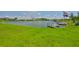Scenic waterfront view from grassy backyard, featuring a dock and boat lift at 1811 Milford Cir, Sun City Center, FL 33573