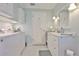 Well-lit laundry room with washer, dryer, white cabinetry, and sink at 1811 Milford Cir, Sun City Center, FL 33573