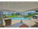 Relaxing screened pool area with brick border, patio furniture, and view of the water at 1811 Milford Cir, Sun City Center, FL 33573