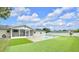 A view of the backyard showcasing green space, an inground pool and an enclosed patio at 2106 Sherbrook Dr, Valrico, FL 33594
