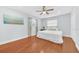 Cozy bedroom with hardwood floors, a ceiling fan, a comfortable bed, and ample natural light at 2106 Sherbrook Dr, Valrico, FL 33594