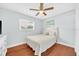 Well-lit bedroom with wood floors, a ceiling fan, and a beach-themed decor at 2106 Sherbrook Dr, Valrico, FL 33594