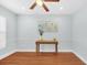 Sunlit bedroom featuring classic hardwood floors, decorative trim, a wooden desk, and a ceiling fan for added comfort at 2106 Sherbrook Dr, Valrico, FL 33594